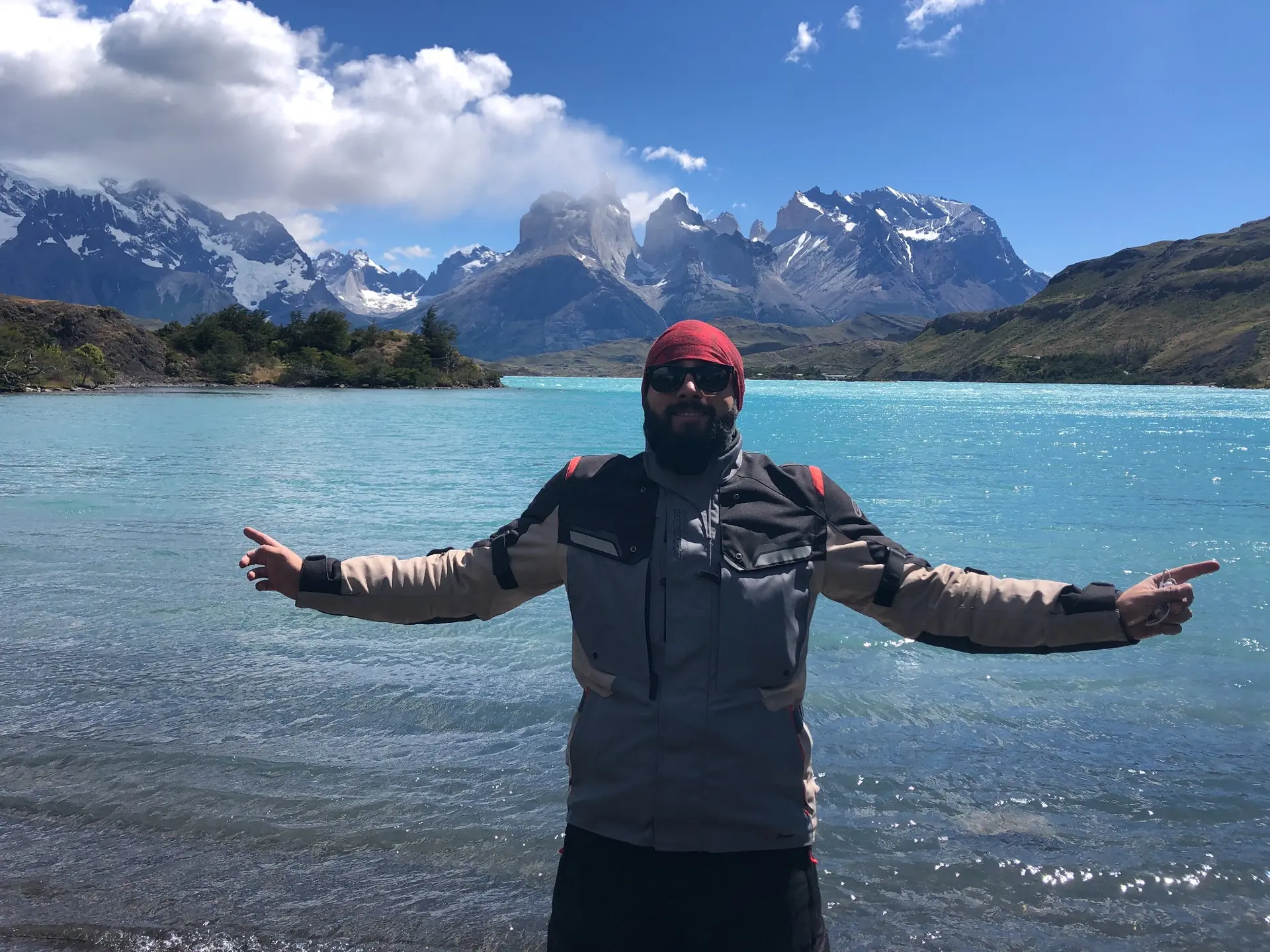 Thiago Berardi de braços abertos diante dos picos de Torres del Paine, na Patagônia
